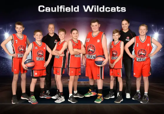 Caulfield Wildcats junior basketball team and coaches posing in red uniforms with basketballs.